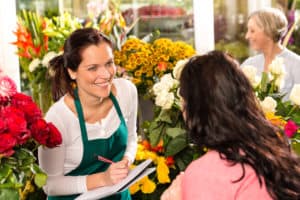 Happy florist writing flower shop talking customer facebook advertising myths
